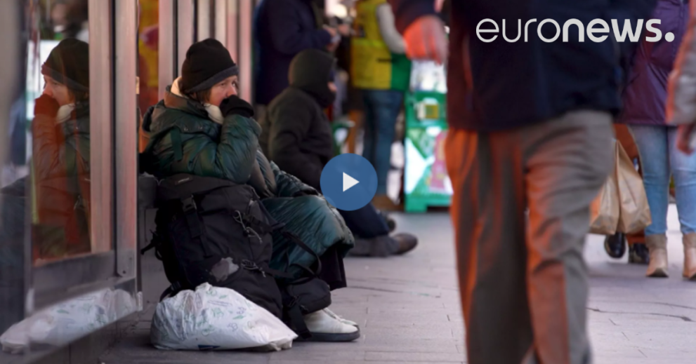 Homeless woman sitting in a shop window in the street´s of Madrid 